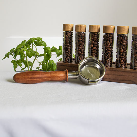 Bottomless wooden portafilter near coffee beans cellars from far away