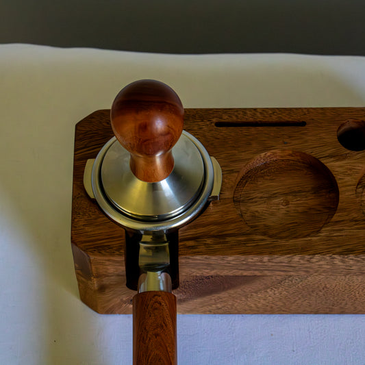 Wooden coffee tamp with metal base on a white surface