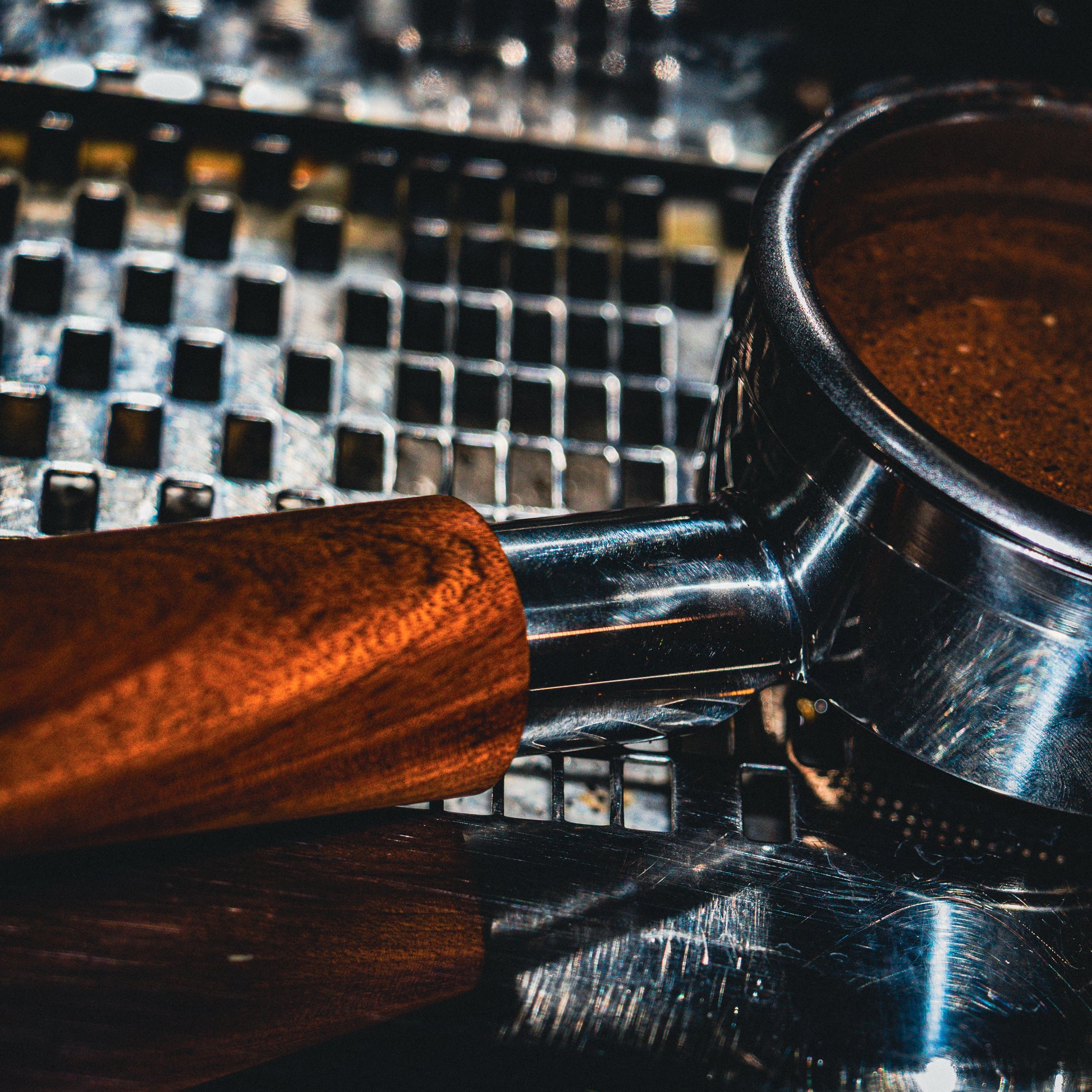 Close-up of a coffee grinder with coffee beans on a metallic surface