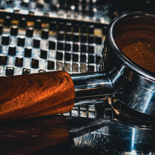 Close-up of a coffee grinder with coffee beans on a metallic surface