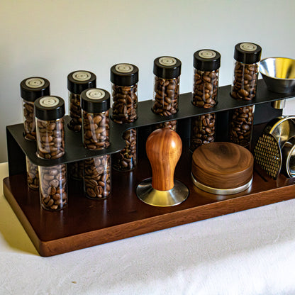 Set of coffee beans in jars with a wooden and metal tamp on a white surface