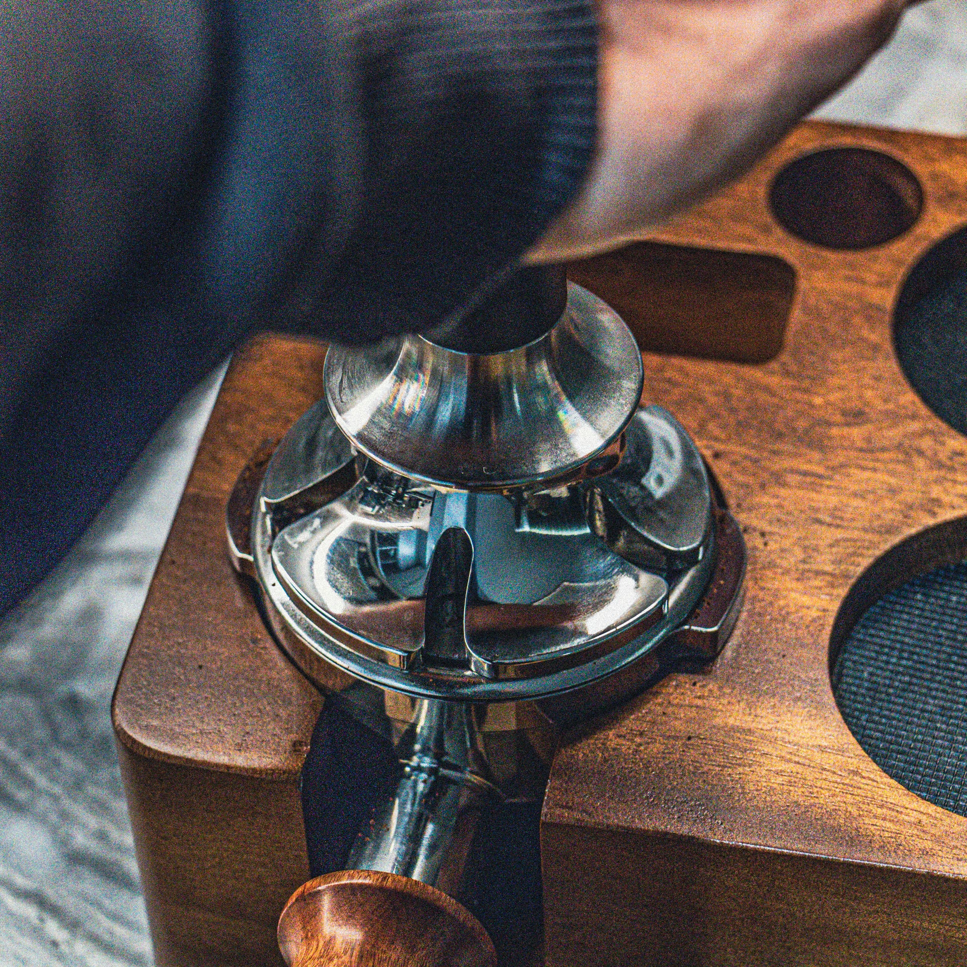 Close-up of a espresso tamper being used to tamp coffee