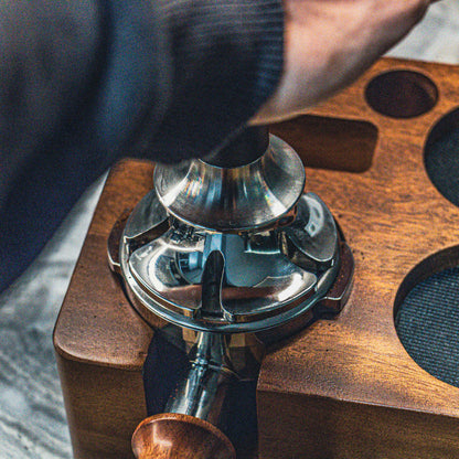 Close-up of a espresso tamper being used to tamp coffee