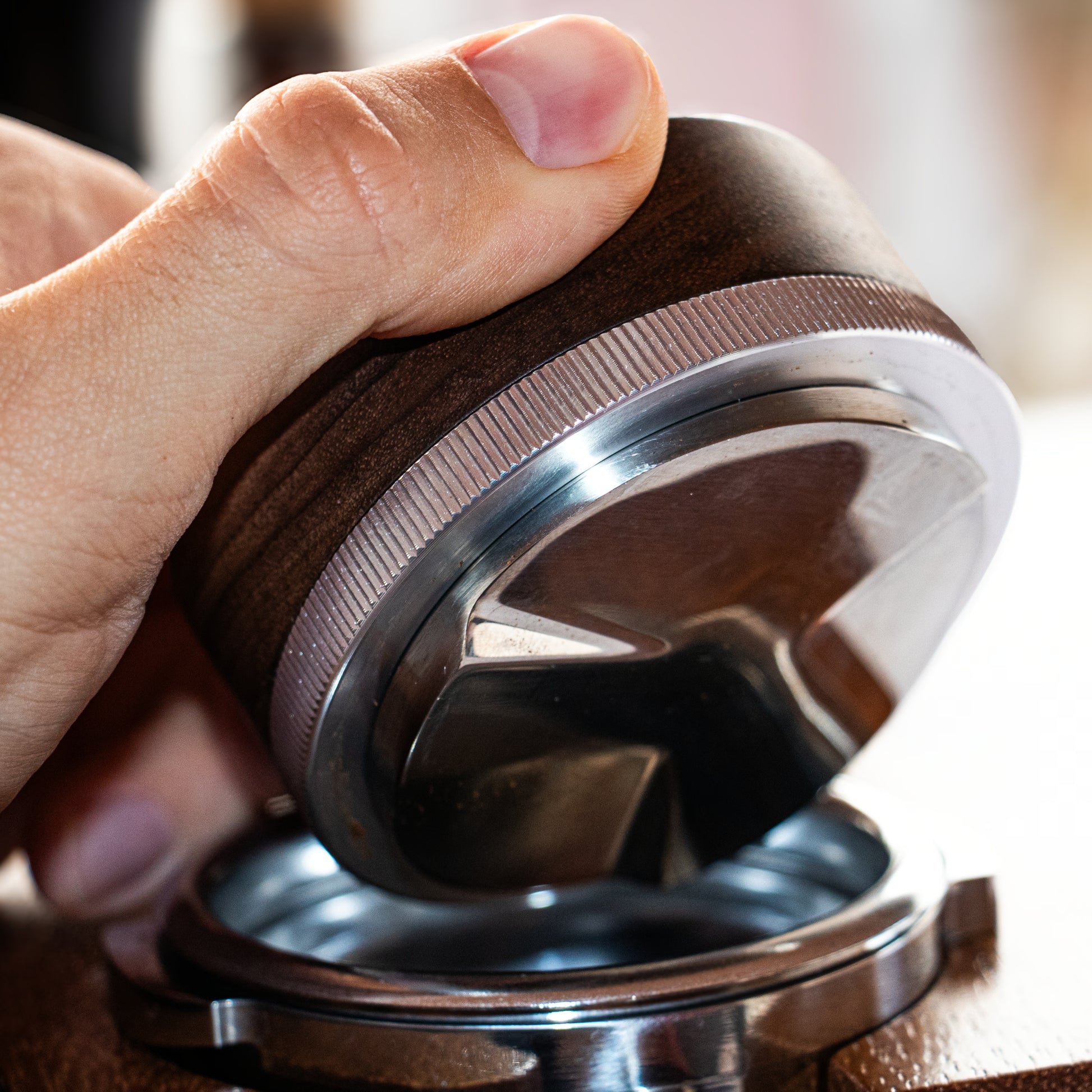Wooden espresso distribution tool close up in hand