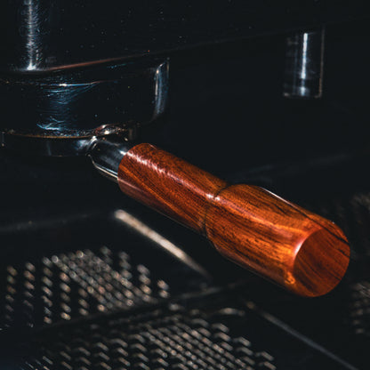 Close-up of a portafilter with a wooden handle in use